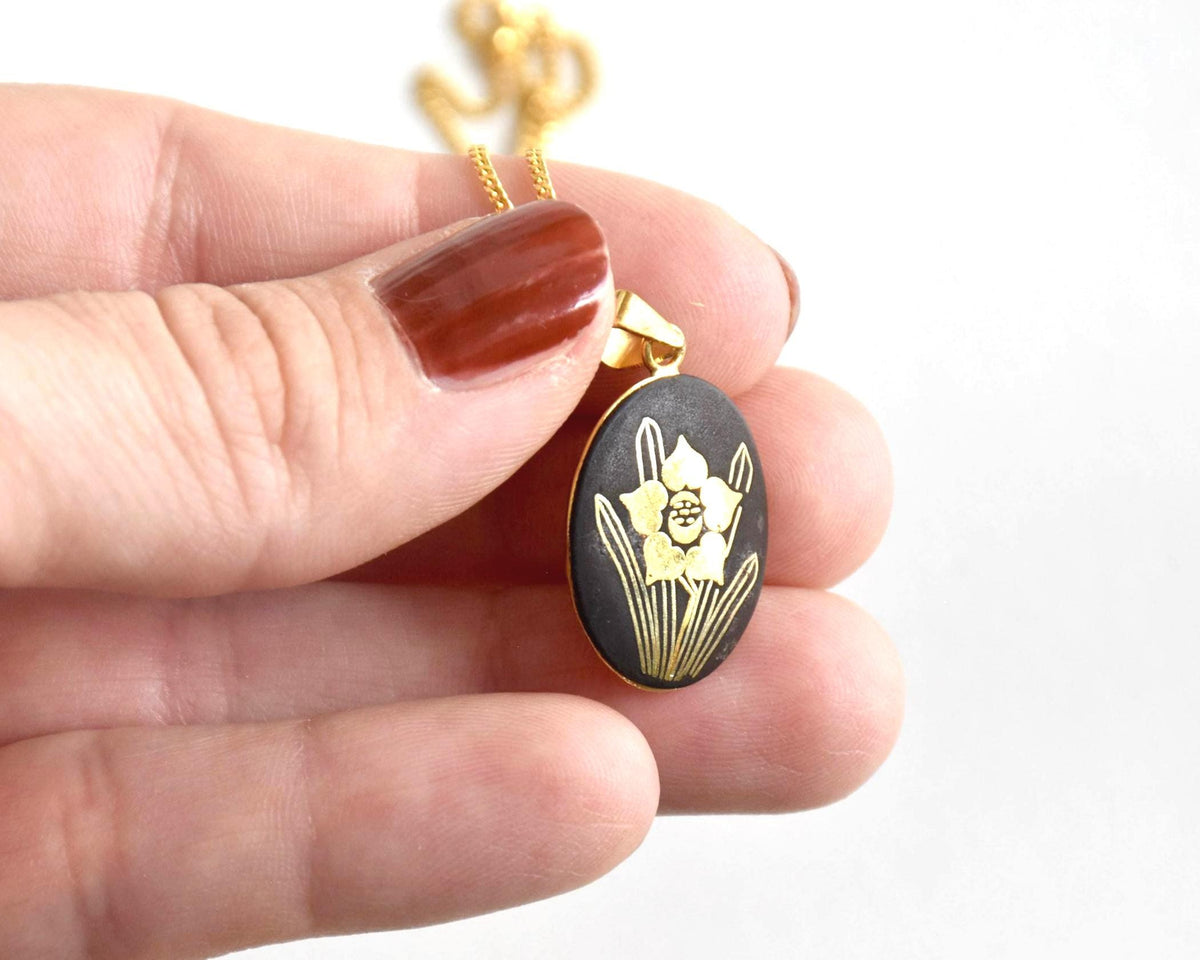 Japanese Zogan floral pendant necklace showing size next to a hand
