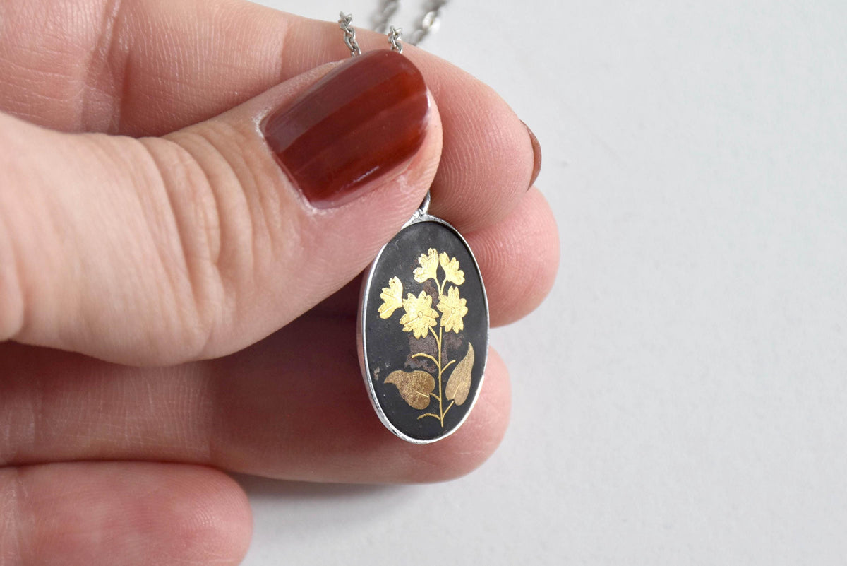 Japanese Zogan Floral Pendant Gold Inlay Damascene necklace angled view in hand