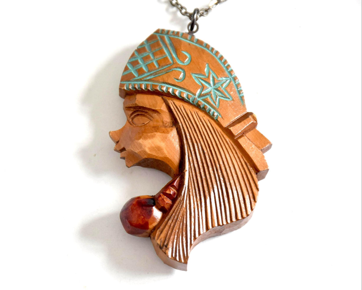 Ainu double-sided wooden pendant necklace close-up showing the intricate star and geometric pattern engravings