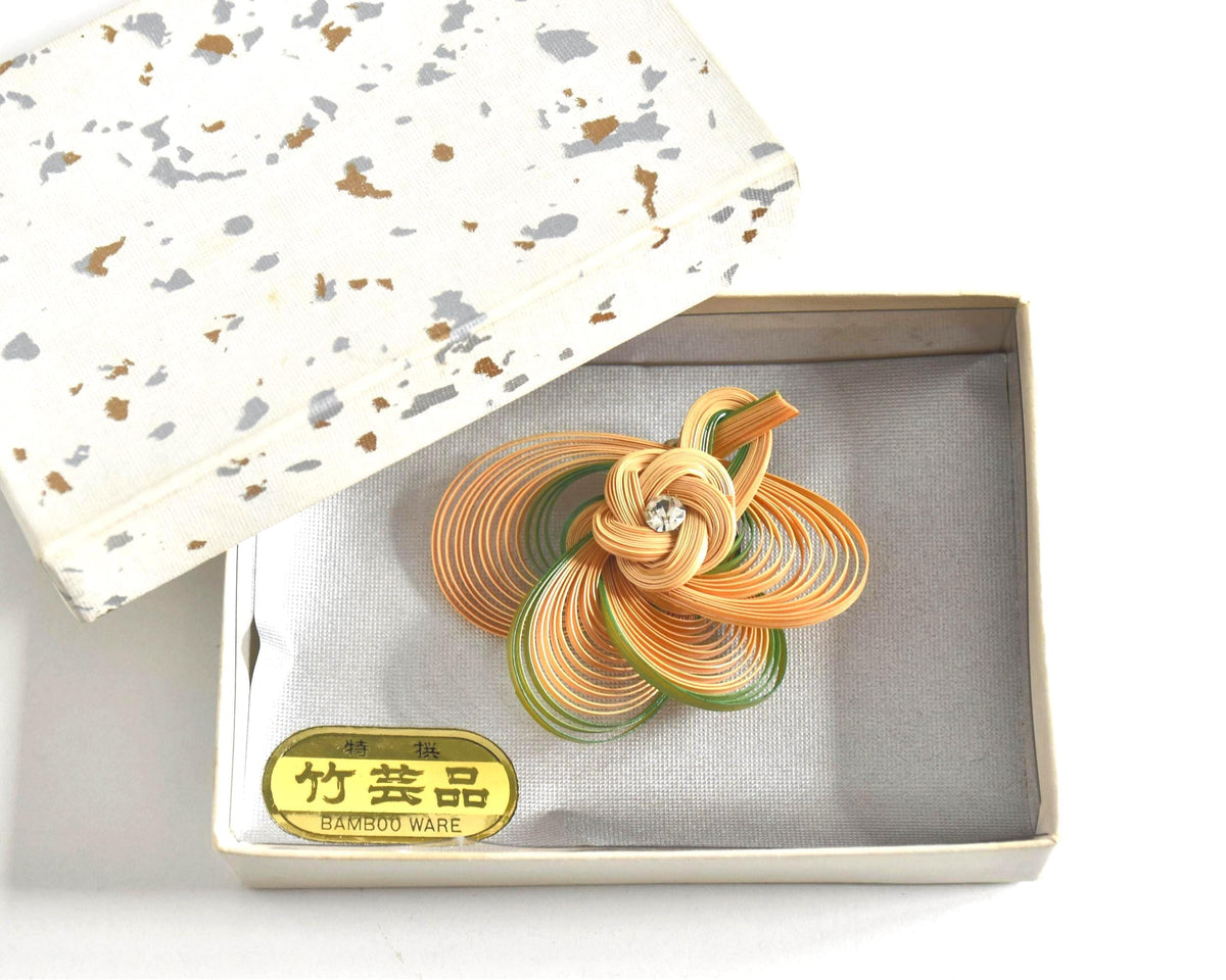 Hand-Woven Bamboo Knot Brooch In Beige And Green resting in its presentation box