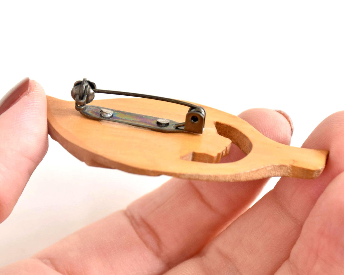 Ainu hand-carved wooden brooch back showing metal roll-over safety pin clasp