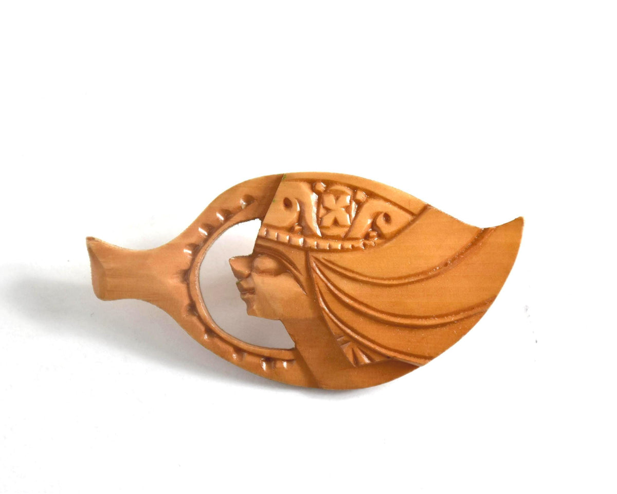 Ainu hand-carved wooden brooch isolated on white background