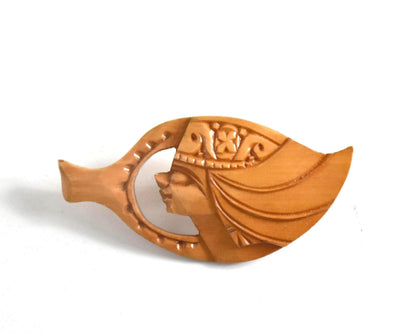 Ainu hand-carved wooden brooch isolated on white background