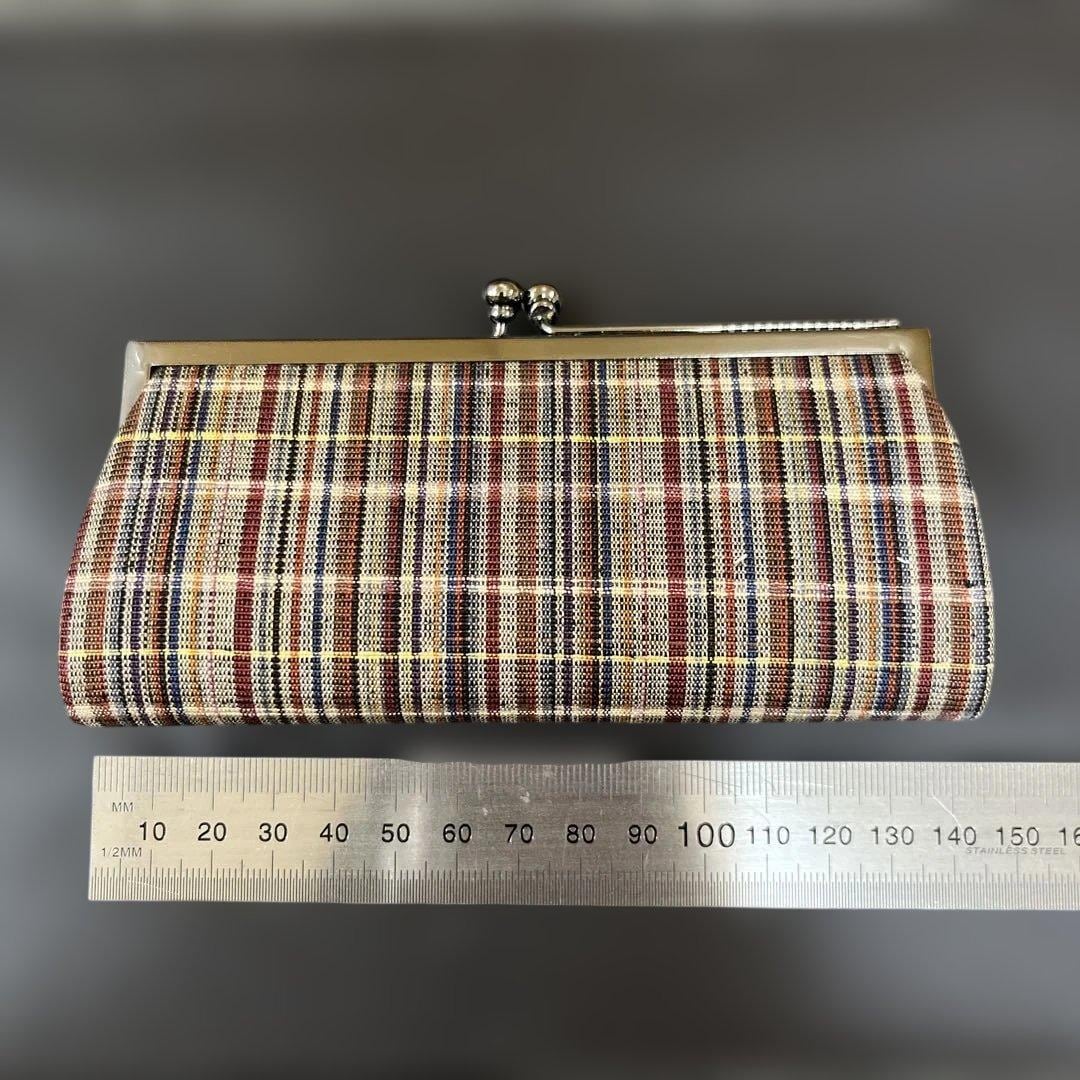 Ueda Tsumugi silk coin purse placed beside a metal ruler for size reference