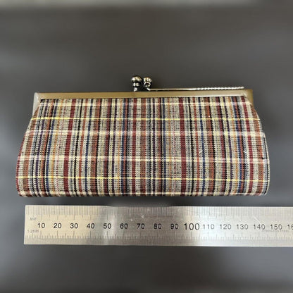 Ueda Tsumugi silk coin purse placed beside a metal ruler for size reference