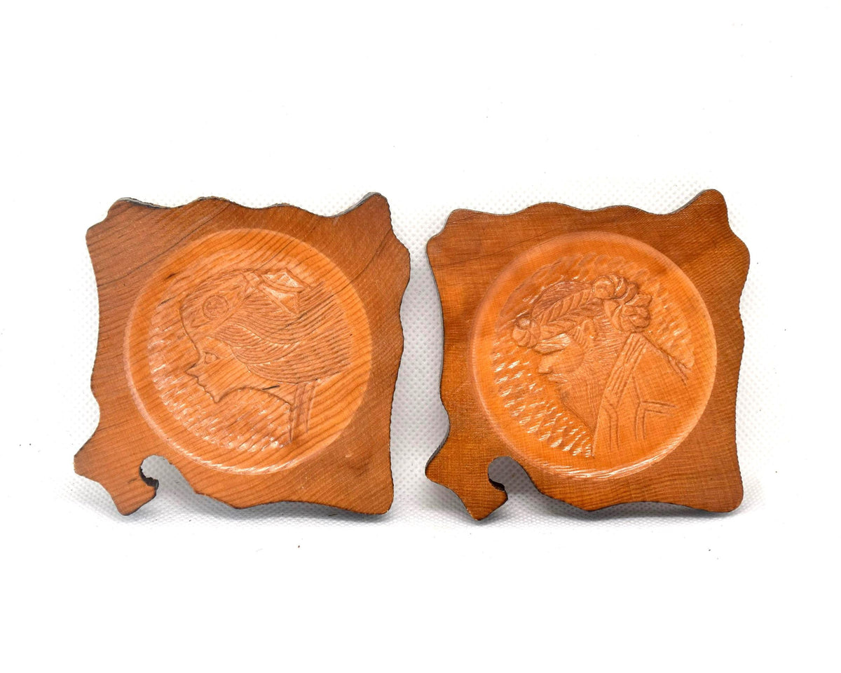 Ainu wooden coaster set displayed side by side showcasing both carved figures