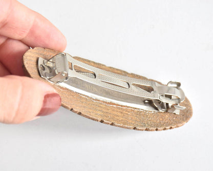 Ainu wooden hair barrette showing the back metal clasp attached to the wood grain base