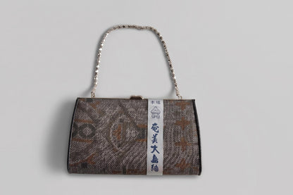 Amami Oshima Tsumugi silk clutch hanging view with chain strap