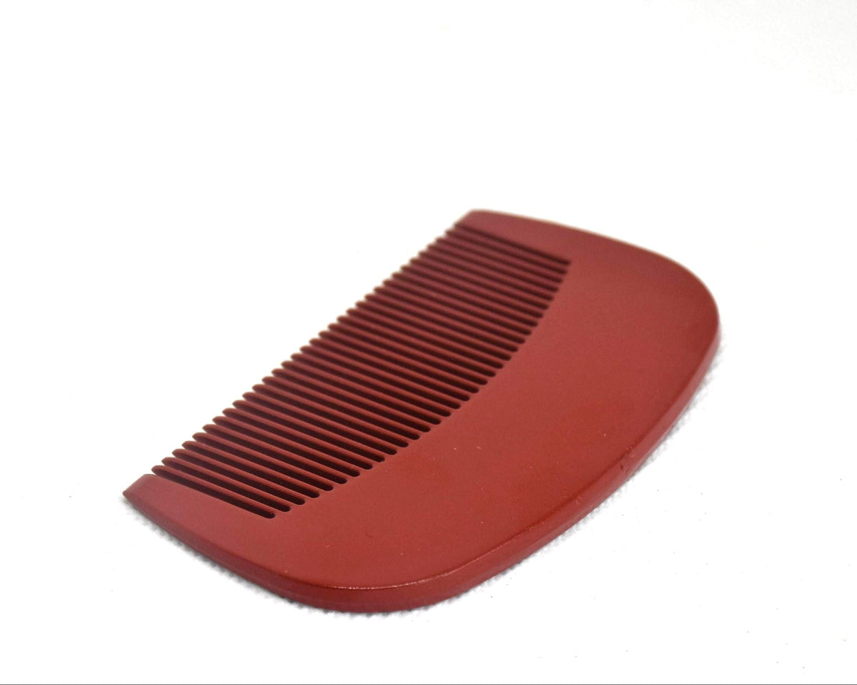 Toyama Urushi Kushi comb showing the plain red backside with minor surface scratches