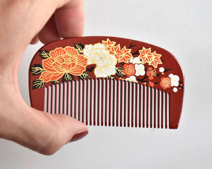 Toyama traditional hair comb close-up view displaying the detailed peony, plum blossom and maple leaf motif