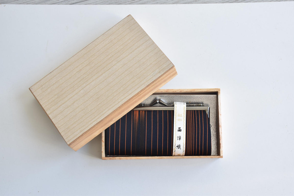 Nishijin-Ori Silk Gamaguchi Purse Black Copper Stripe resting in its open kiribako box