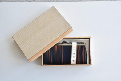 Nishijin-Ori Silk Gamaguchi Purse Black Copper Stripe resting in its open kiribako box