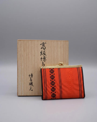Vermilion Hakata-Ori Silk Clasp Coin Purse displayed upright next to its inscribed wooden box