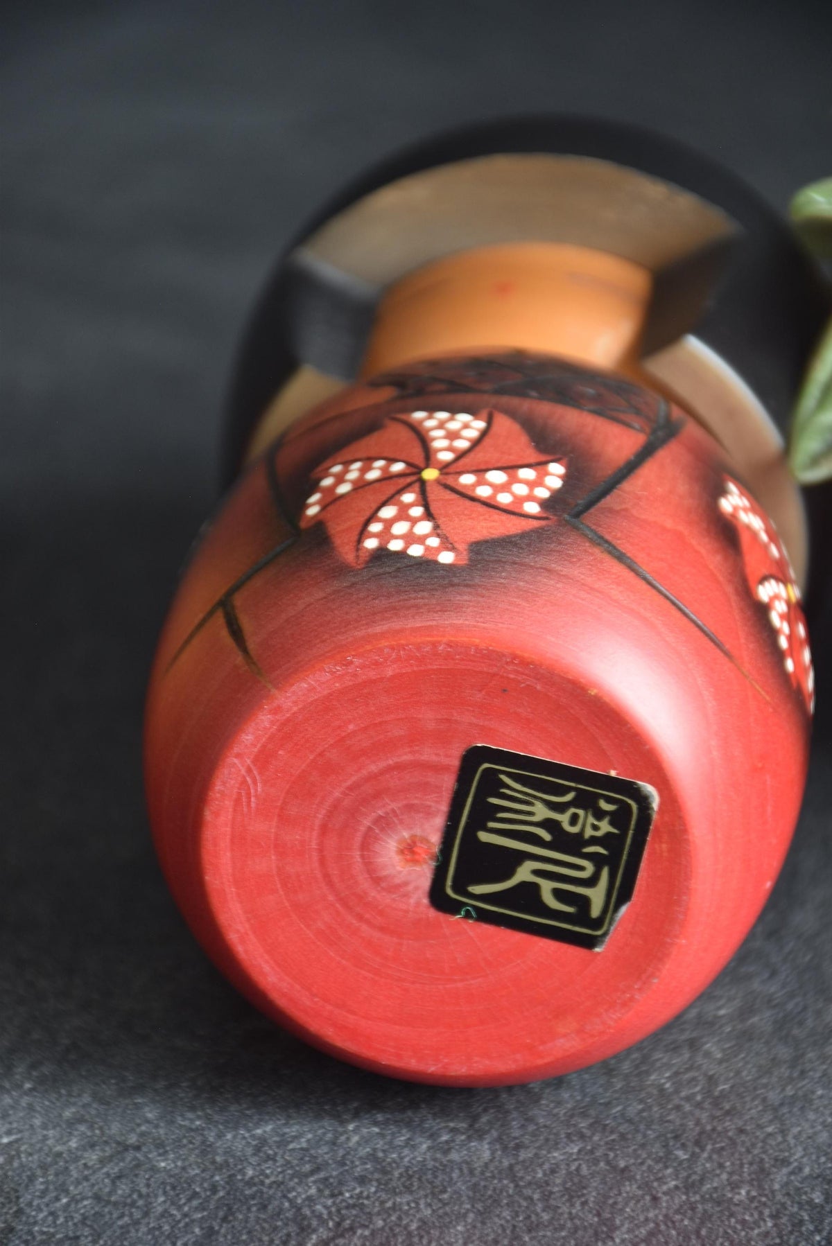 Masae Fujikawa kokeshi doll base showing wood grain and carved signature mark