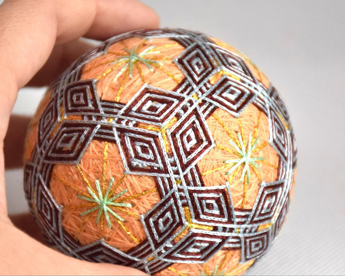 Hand-Embroidered Japanese Temari Folk Art Ball shown next to a hand