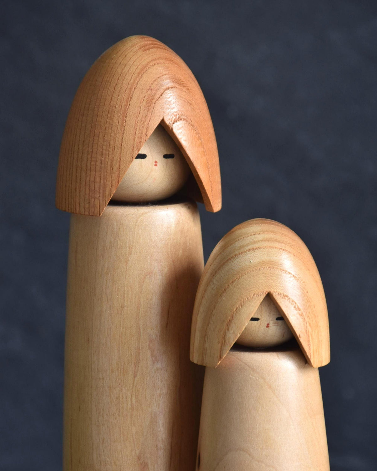 Shido Shozan kokeshi pair close-up of faces in hooded capes