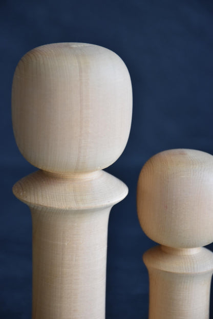 Isamu Ise kokeshi dolls close up of the smooth carved wooden head shapes.