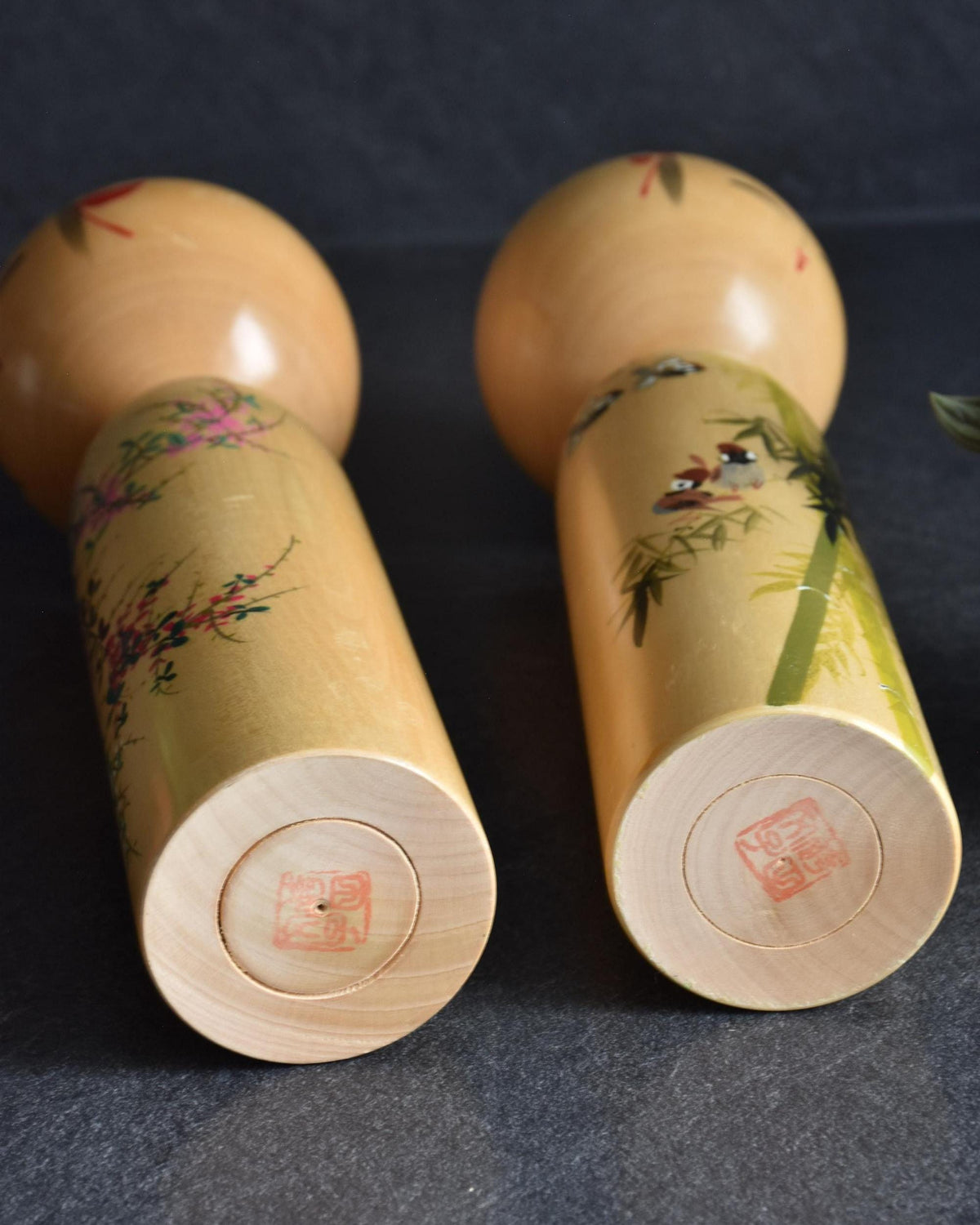 Pair of Japanese kokeshi dolls bamboo and floral motif bases