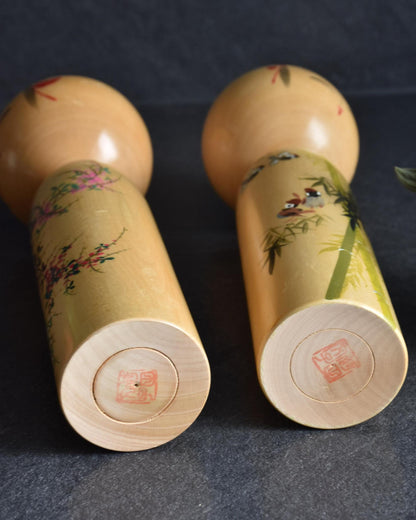 Pair of Japanese kokeshi dolls bamboo and floral motif bases
