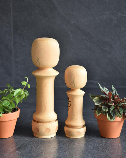 Isamu Ise kokeshi dolls showing the plain wooden back view with simple grain.