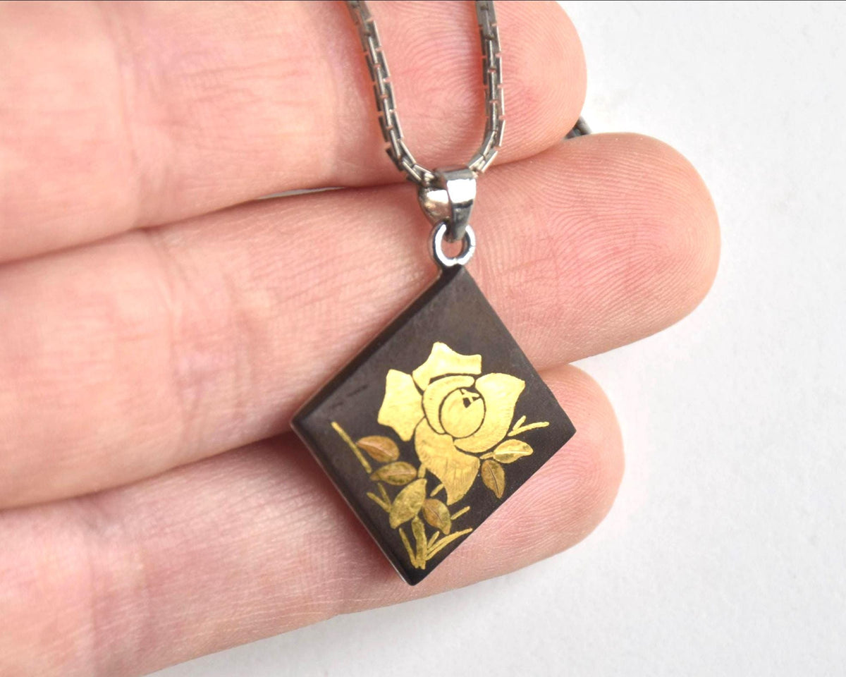 Japanese Zogan Floral Damascene Pendant Necklace held close up showing the rose motif