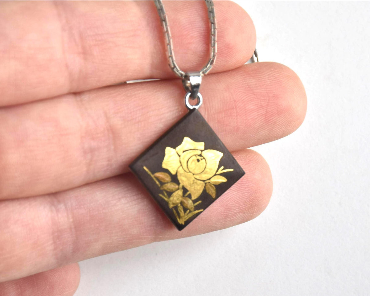 Japanese Zogan Floral Damascene Pendant Necklace held in hand showcasing the square pendant