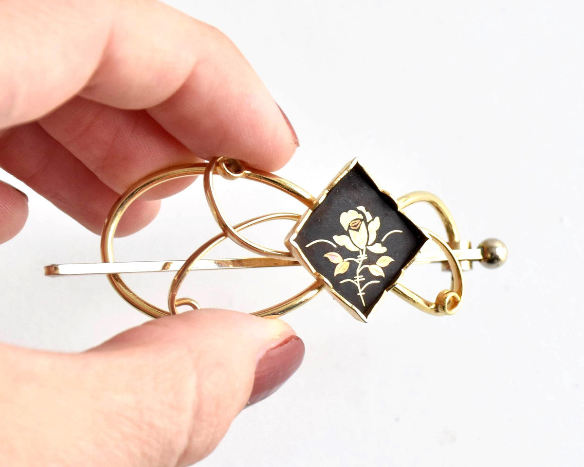 Floral Zogan Damascene Hair Ornament Gold And Black Japanese hairpin held next to a hand for size