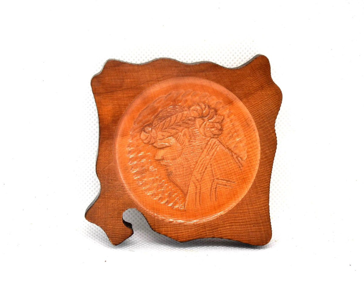 Ainu wooden coaster featuring the detailed profile carving of a bearded man