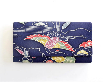 Navy Chirimen Kimono Clutch With Tsuru Crane Motif resting horizontally on dark surface