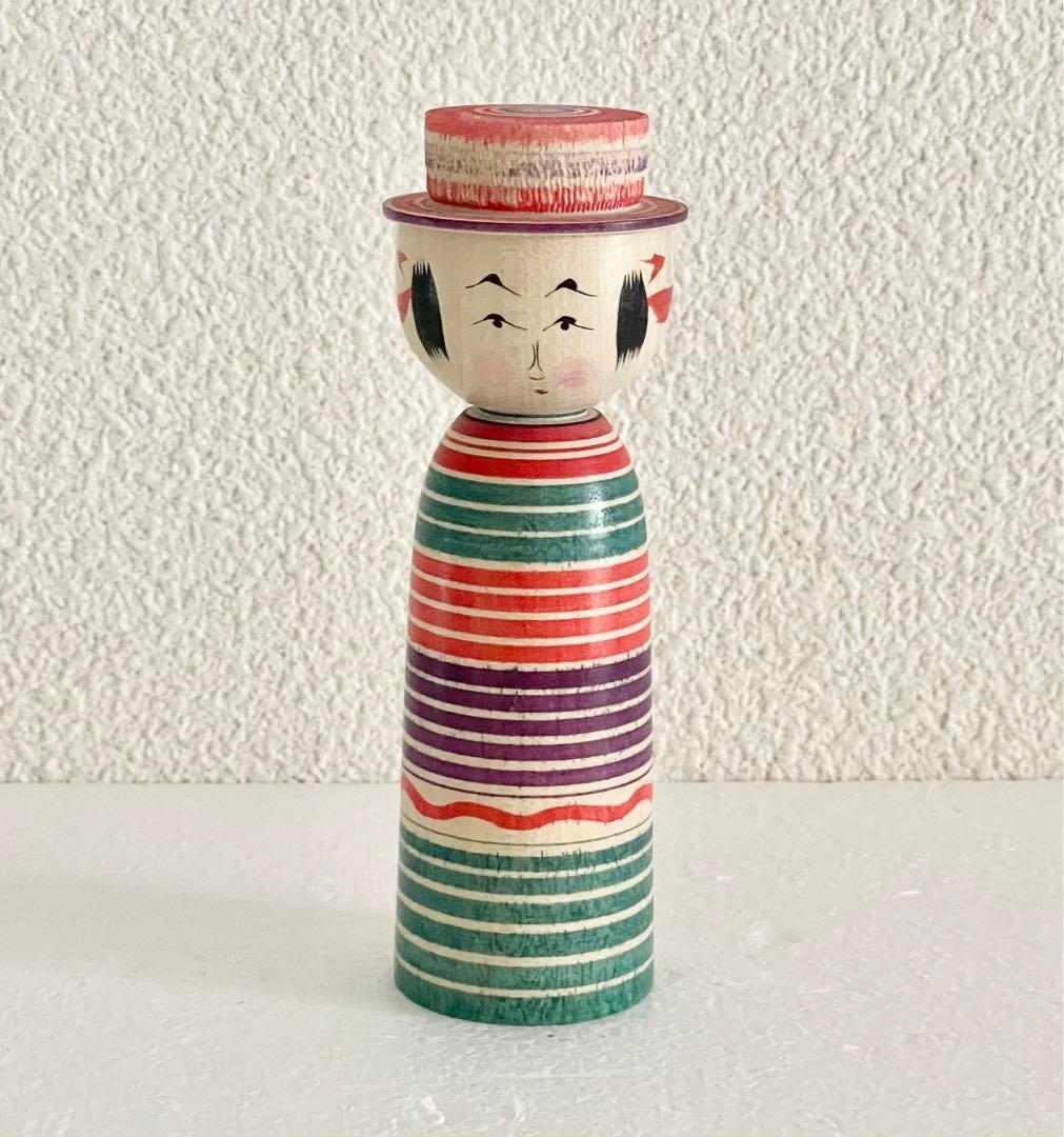 Sadayoshi Hoshi Yajiro Kokeshi Doll With Hat featuring lathe-turned rings and serene expression