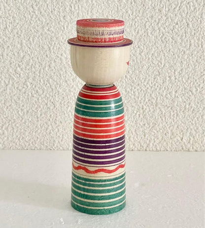 Sadayoshi Hoshi kokeshi doll viewed from the back showing plain wooden head and striped body