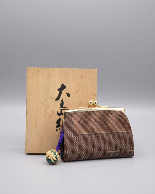 Oshima Tsumugi Mud-Dyed Silk Gamaguchi Coin Purse resting in front of its original wooden box.
