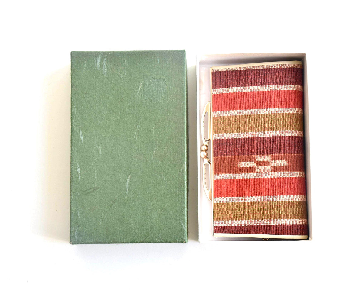 Yaeyama Minsa-Ori coin purse resting inside its open original green storage box