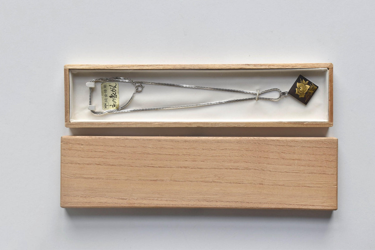 Japanese Zogan Floral Damascene Pendant Necklace displayed with its wooden box lid beside it