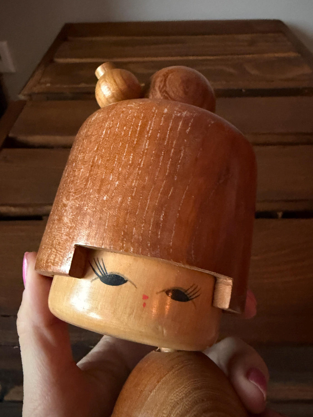 Masuo Sato kokeshi doll held in hand showing size next to fingers