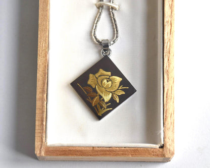 Japanese Zogan Floral Damascene Pendant Necklace positioned inside the open wooden box