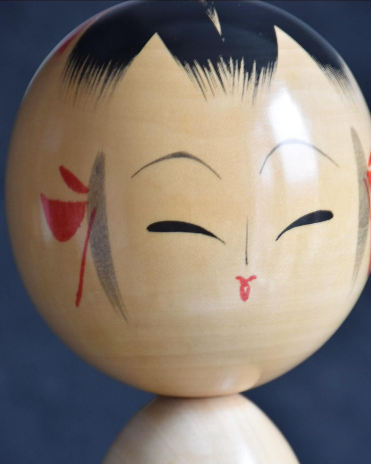 Pair of Japanese kokeshi dolls bamboo and floral motif face close up