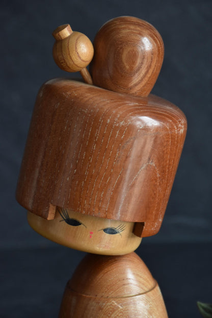 Masuo Sato kokeshi doll close-up on the face and carved hair ornament