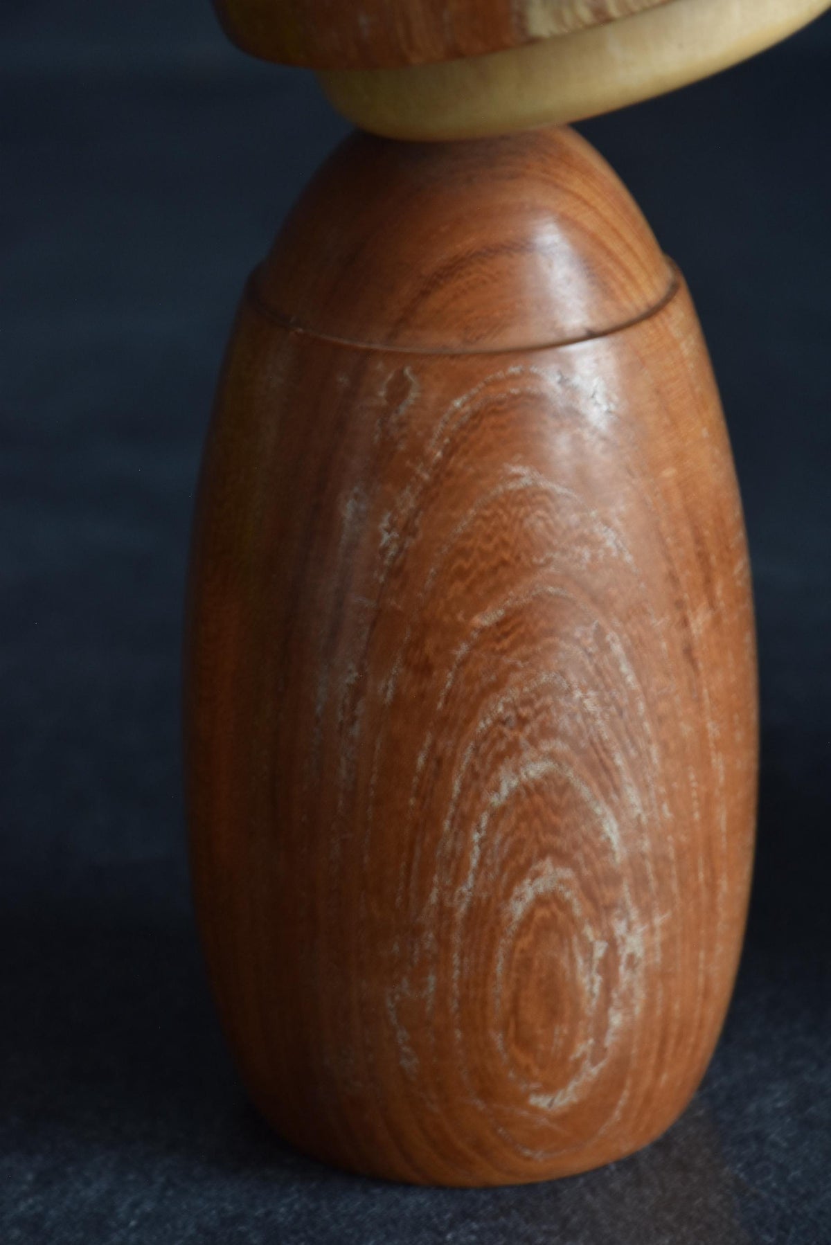 Masuo Sato kokeshi doll detail of surface texture and wood grain on the lower body