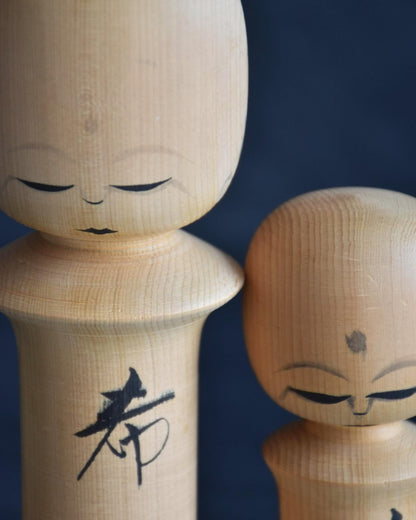 Isamu Ise kokeshi dolls close up of serene painted facial features and kanji.