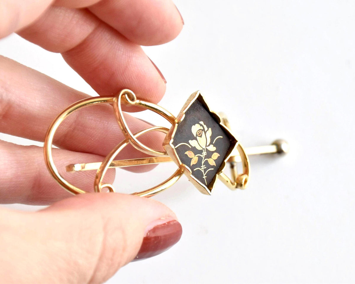 Floral Zogan Damascene Hair Ornament Gold And Black angled view showing the hair clip held by hand