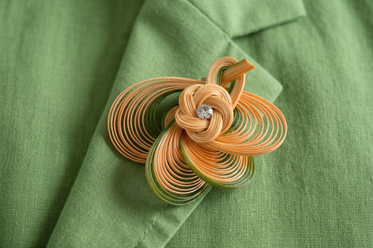 Hand-Woven Bamboo Knot Brooch In Beige And Green styled on a green jacket