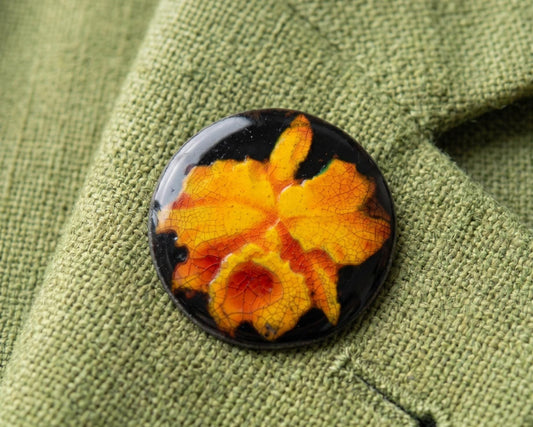 Kutani Ceramic Brooch Orange Glaze Hand-Painted Pin attached to green textured fabric