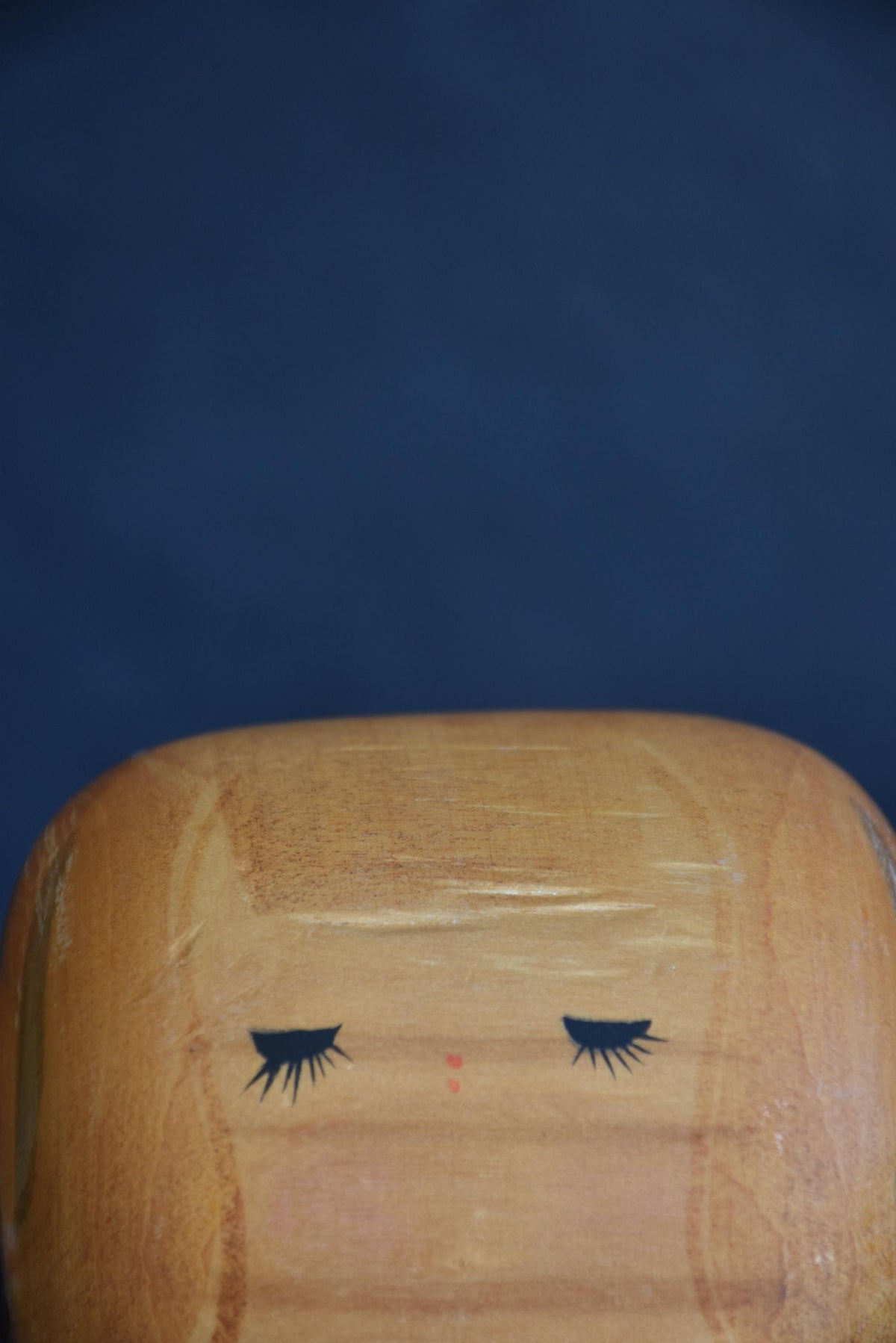 Hajime Miyashita Sosaku Kokeshi Red Geometric Ribbon closeup of face with closed eyes