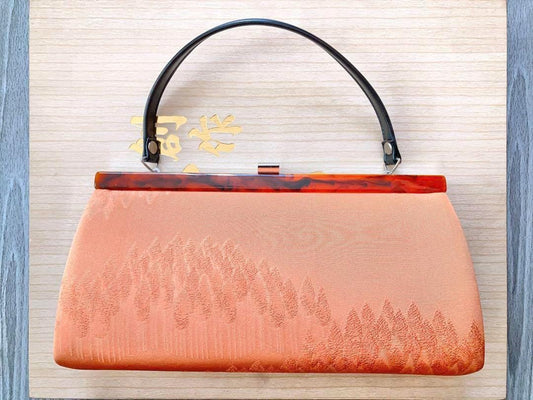 Salmon Geometric Woven Kimono Clutch With Tortoiseshell featuring a lightly padded salmon-orange woven fabric and