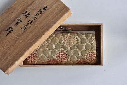 Hakata-Ori Saga Nishiki Geometric Silk Clasp Purse angled view inside the tomobako wooden gift box