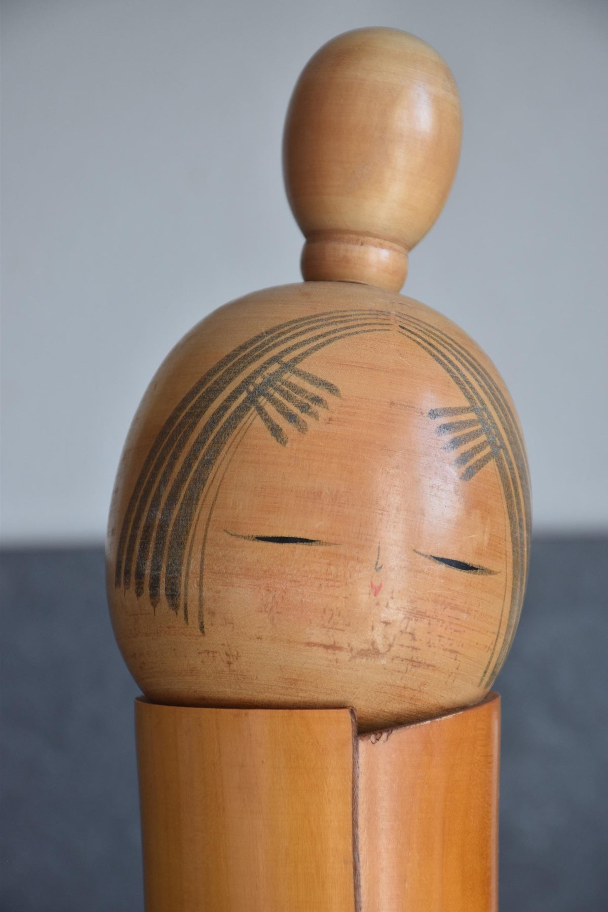Sato Suigai Kiku No Omoi kokeshi doll head with smooth black bun and closed eyes