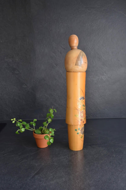 Sato Suigai Kiku No Omoi kokeshi doll viewed from the left side showing floral details