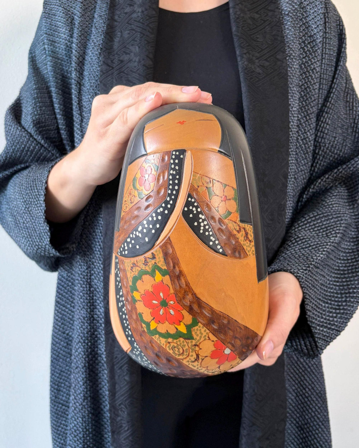 Ishimura Sosaku kokeshi doll held in hands to show scale and size