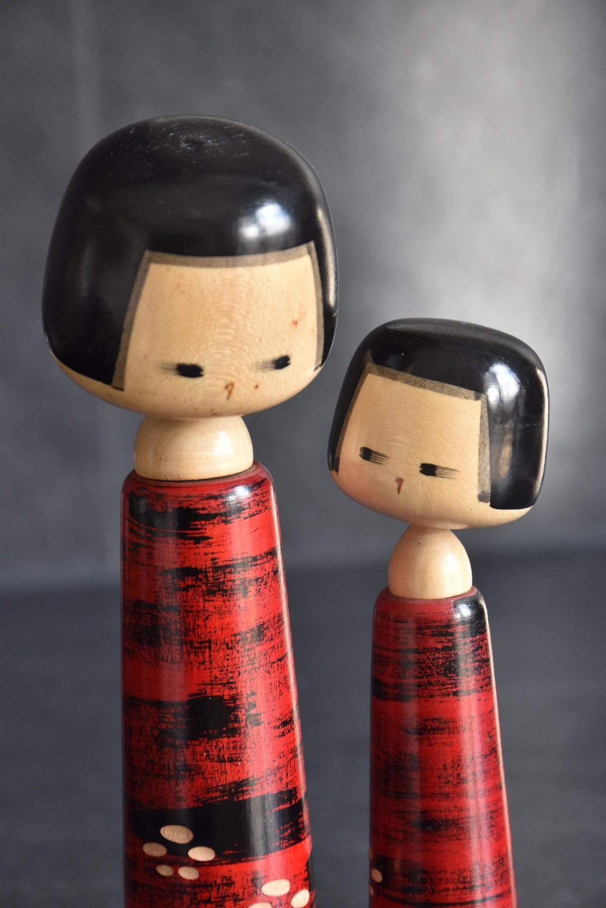 Aida Seihou kokeshi Sisters close up of the minimalist painted faces and glossy black bob haircuts